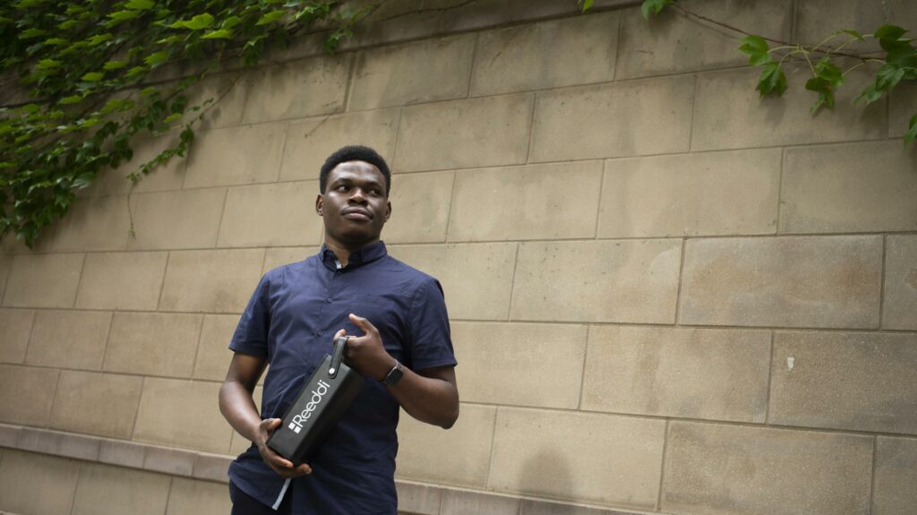 Reeddi's Olugbenga Olubanjo with Reeddi Box in front of walll